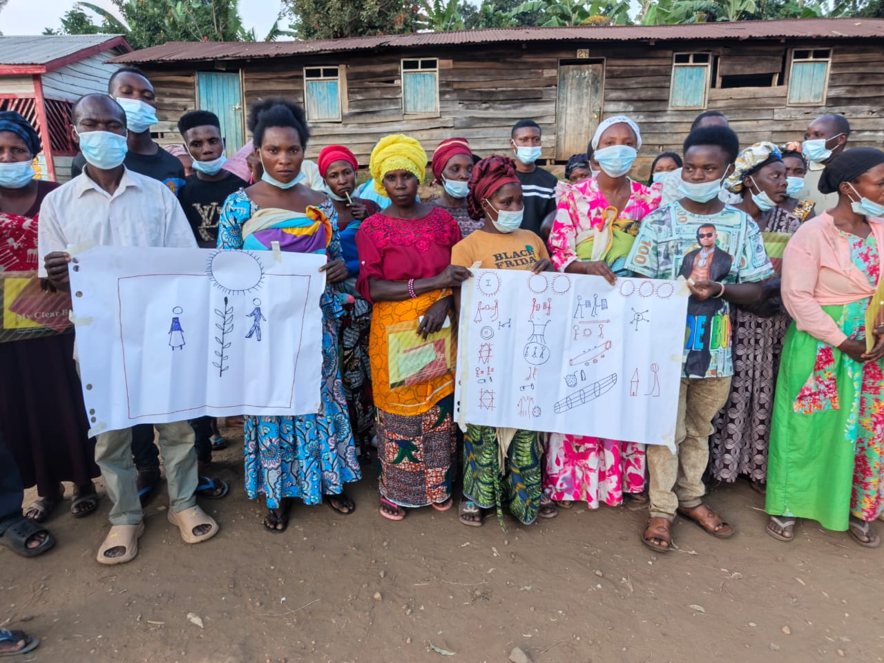 Women displaying Gender Action Learning System diagrams in Mbasha